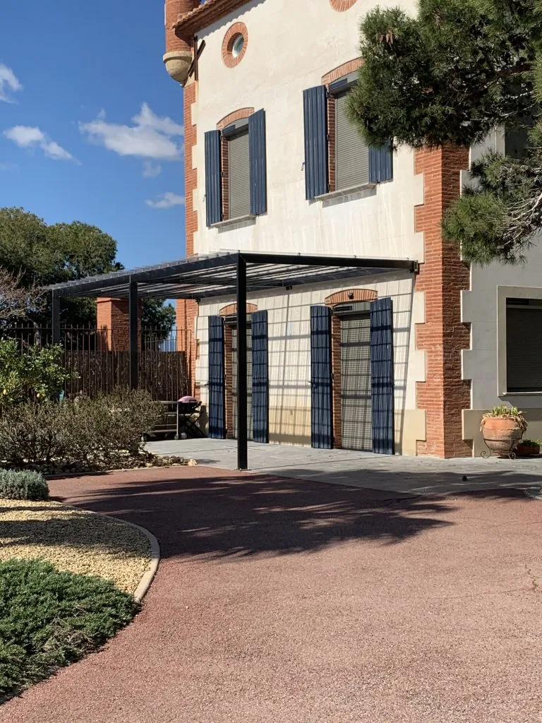 Pergola en acier adossée à une maison de caractère